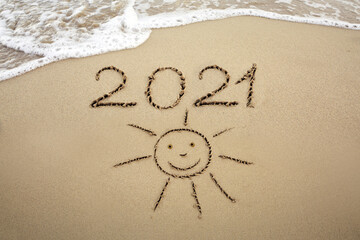 Year 2021 written at the caribbean sand beach with Sun drawing