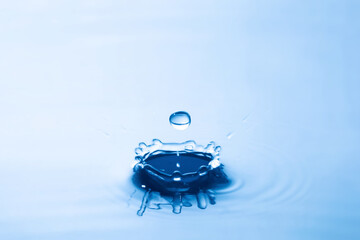 Water droplet falling impact with water surface. causing rings on water surface.