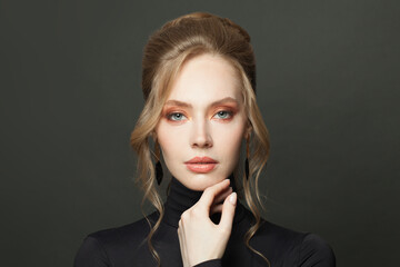 Beautiful woman face. Elegant woman with hair bun hairdo wearing black turtleneck sweater