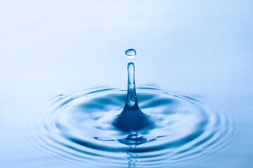 Water droplet falling impact with water surface. causing rings on water surface.