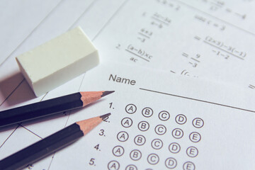 Pencil and eraser on answer sheets or Standardized test form with answers bubbled. multiple choice answer sheet