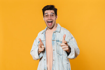 Photo of excited young man in eyeglasses pointing fingers at camera