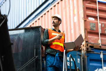 foreman maneger working through a radio communication with the workers in the container yard at...