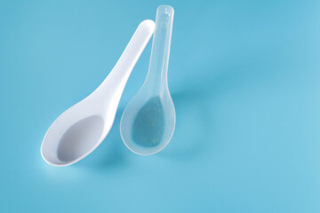 white plastic spoon on blue background