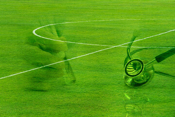 metal stethoscope for medical doctor heath analysis with green football or soccer sport field...