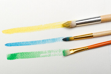 Fototapeta premium Closeup of colorful lines of watercolor and brushes on the paper