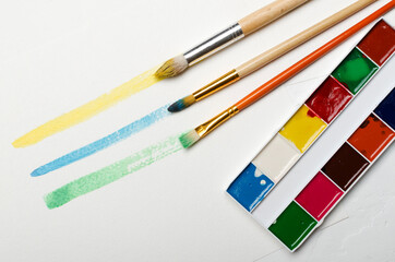Top view of watercolor lines, brushes, set of watercolor on the white paper