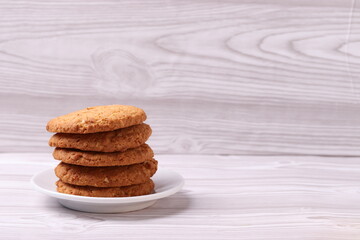 homemade cookies and a glass cup of black tea on the rustic white wooden background. close up