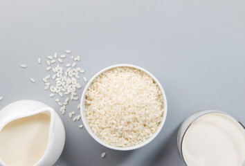 Vegan Rice milk with rice grains on gray background. Copy space, top view
