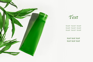 A tube of green with a transparent aloe vera gel. On a white background among green leaves. Blank for text