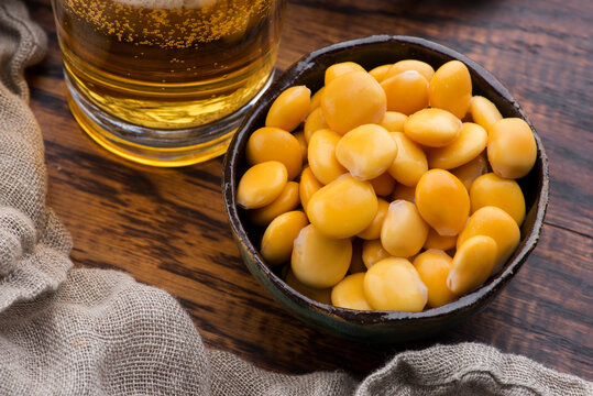 Tasty lupins and glass of beer. Beverage, legume.
