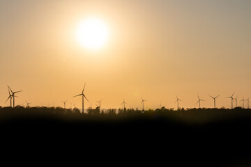Fototapeta na wymiar Black Silhouette of windturbines energy generator on amazing sunset at a wind farm in germany