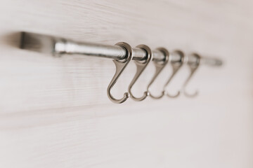 Iron hooks on the kitchen wooden wall.