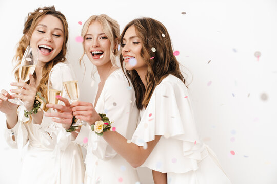 Photo of excited beautiful bridesmaids laughing and drinking champagne