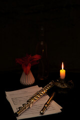 Still life with flowers, candles, Japanese apple and flute