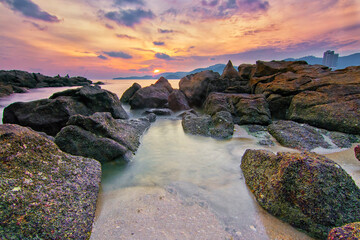 Great rocky beach sunset view with soft focus effect due to long exposure technique