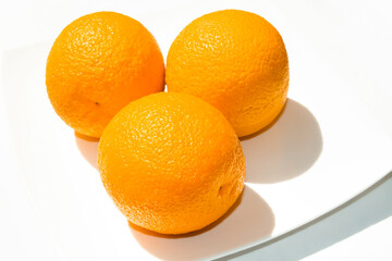 Oranges on a plate. Orange on a white background.