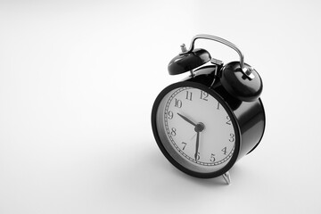 Black vintage alarm clock on table. White background. Wake up concept. An image of a retro clock showing 09:30 pm/am. 