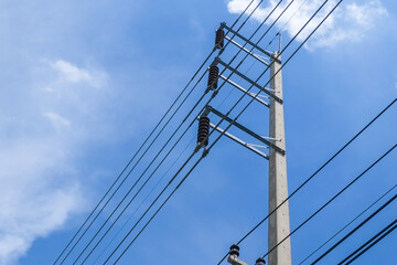 Cement high voltage pole and electric wire with fuse and white cloud with blue sky with copy space.