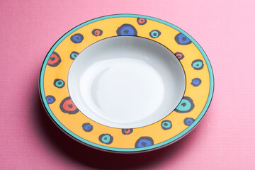 One round yellow plate isolated on a pink background