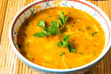 a bowl of soup, vegetables and noodles, hot food
