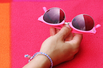 Hand Holding  sunglasses on fleece rug background 