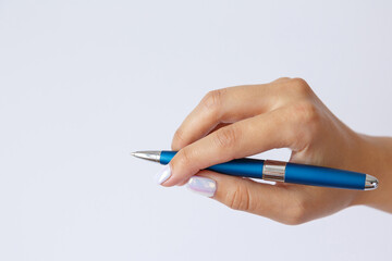 Gesture and sign, female hand holding a metal blue pen on a white background