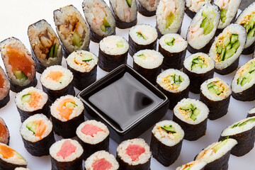 Various kinds of sushi roll set served on cutting board. Japanese food