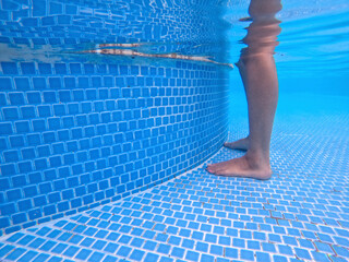 female leg standing in shallow swimming pool.