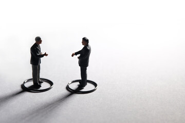Two businessmen make partnership agreement with maintain physical distance. Miniature people conceptual photography