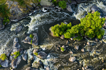 Many rapids with waterfalls, spray foam and whirlpools close-up, rotate the camera. View from drone. Ural region, Russia. The threshold Revun