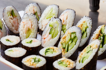 Various kinds of sushi roll set served on cutting board. Japanese food