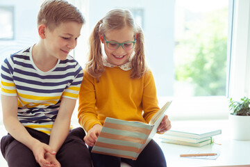 Fototapeta premium Two happy children reading funny book at holidays