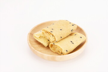 Crispy egg rolls with sesame seeds in a wooden bowl