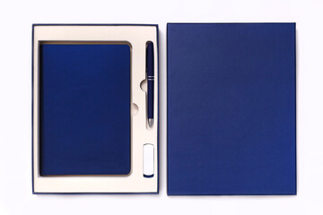Fototapeta premium Corporate style box with pen, flash drive and notebook isolated on white background. View from above