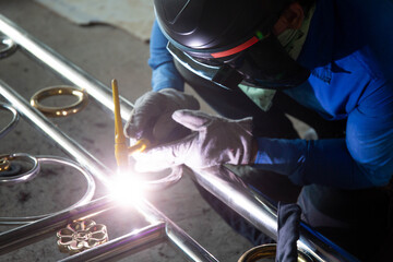 Welders are welding the various parts of building a stainless steel door.