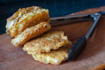 Fried chops in batter on a wooden cutting board.