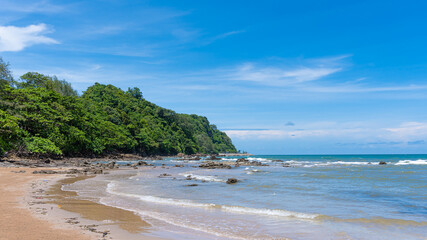 Peaceful tropical coast with clear skies, few clouds and reefs.
