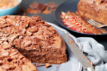 Chocolate cake piece with chocolate and fruits on black rustic table