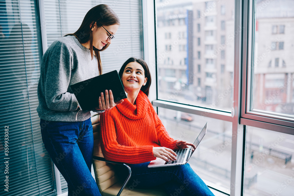 Aufkleber hipster student consulting with successful young businesswoman which working at modern laptop comput