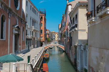 Small canal in Venice, with bridge and boat and buildings
