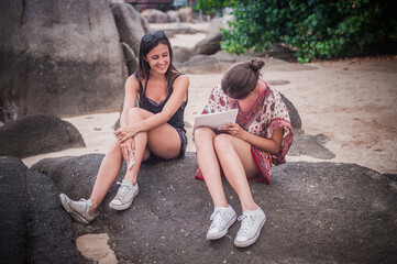 Two casual model girl signing model release in the nature on summer time. Photography modelling concept