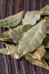 ground dried bay leaf on dark wooden rustic background