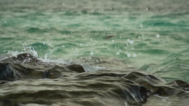 Splash of ocean water on rocks creating beautiful patterns, slow motion