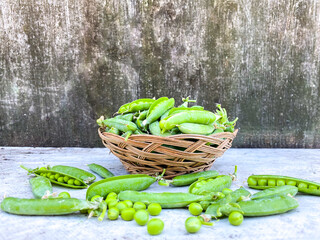Pods of ripened raw peas on an abstract surface. The concept of healthy proper nutrition and agriculture. Free space. Defocus light background.