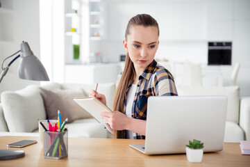 Photo of beautiful lady concentrated student look screen notebook sit table online examination conference education pass session tasks writing diary notes social distance stay home indoors