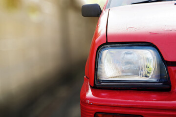 close up of front view of red old car was in front of the house