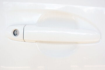 close up of White car door handle with lock hole