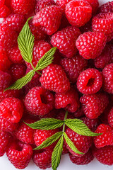 Juicy fresh natural raspberries on white acrylic background