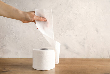 Hand tearing off piece of toilet paper